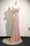 Pink evening gown with gold accents on a mannequin against a white wall.