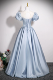 Light blue evening gown on a mannequin against a plain background