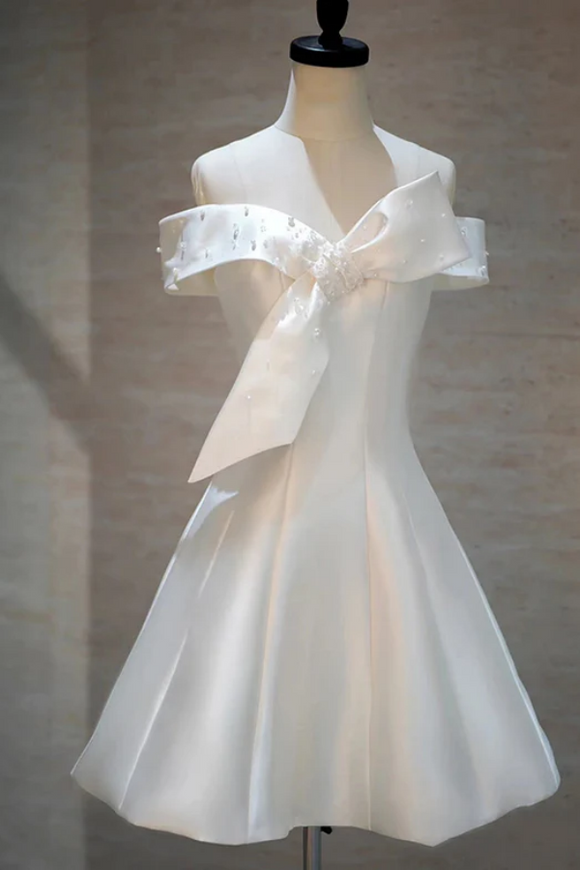 White dress with a large bow on a mannequin against a neutral background