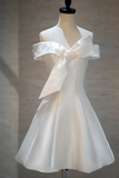 White dress with a large bow on a mannequin against a neutral background