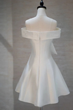 White off-shoulder dress on a mannequin against a neutral background