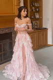 Woman in a pink off-shoulder gown standing in a room with wooden furniture.