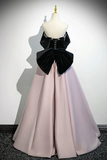 Mannequin wearing a black top with a large bow and a long pink skirt against a white background