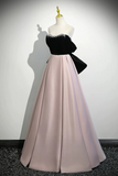 Black and pink evening gown on a mannequin against a plain background