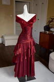 Red evening gown on a mannequin in a room with furniture.