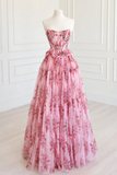 Pink floral strapless gown on a mannequin against a white wall.