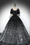 Black sequin evening gown on a mannequin against a gray background