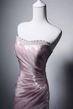 Pink satin dress on a mannequin against a gray background