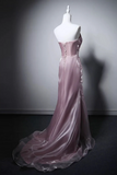 Pink evening gown on a mannequin against a dark background