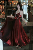 Woman in a red evening gown standing in an indoor setting with blurred background