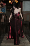 Woman in a red satin dress standing in a dimly lit room.