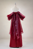 Red evening gown on a mannequin against a plain background