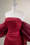 Red dress on a mannequin against a plain background