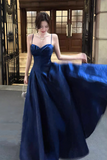 Woman in a blue evening gown standing in an elegant interior setting