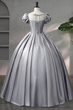 Silver ball gown on a mannequin against a neutral background