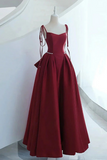 Red evening gown on a mannequin against a white background