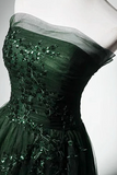 Green evening gown with floral embellishments on a mannequin against a white background