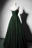 Green evening gown on a mannequin against a plain background