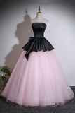 Black and pink strapless gown on a mannequin against a plain background