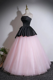 Black top and pink skirt dress on a mannequin against a plain background