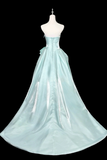 Light blue evening gown on a mannequin against a black background