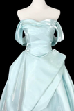 Light blue off-shoulder gown on a mannequin against a black background