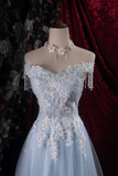 Light blue off-shoulder gown with floral lace details on a mannequin against a dark background.