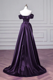 Purple evening gown on a mannequin against a white paneled wall.