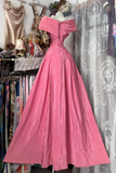 Pink evening gown displayed in a store with other clothing items.
