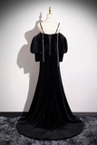 Black evening gown on a mannequin against a plain background