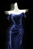 Navy blue evening gown on a mannequin against a black background