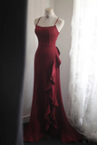 Red evening gown on a mannequin against a white curtain