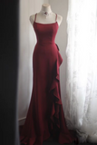 Red evening gown on a mannequin against a white curtain background