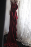 Red evening gown on a mannequin against a white curtain background