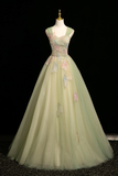 Light green evening gown with floral embroidery on a mannequin against a black background