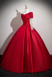 Red ball gown on a mannequin against a plain background