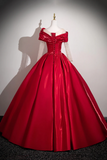 Red ball gown on a mannequin against a plain background