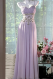 Lavender evening gown with floral decorations on a mannequin against a windowed room background.