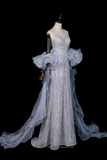 Elegant silver evening gown on a mannequin against a black background
