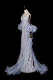 Elegant white evening gown on a mannequin against a black background