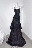 Black evening gown on a mannequin against a white wall