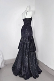 Black sequin evening gown on a mannequin against a white wall.