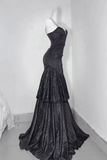 Black evening gown on a mannequin against a white wall