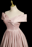 Pink off-shoulder dress on a mannequin against a black background