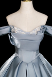 Light blue evening gown with floral details on a mannequin against a black background