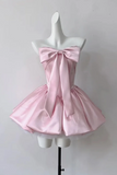 Pink dress with a large bow on a mannequin against a white background