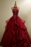 Red evening gown on a mannequin against a plain background