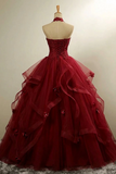 Red ball gown on a mannequin against a plain background