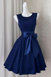 Navy blue dress with a large bow on a mannequin against a neutral background