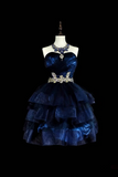 Navy blue dress with embellishments on a mannequin against a black background